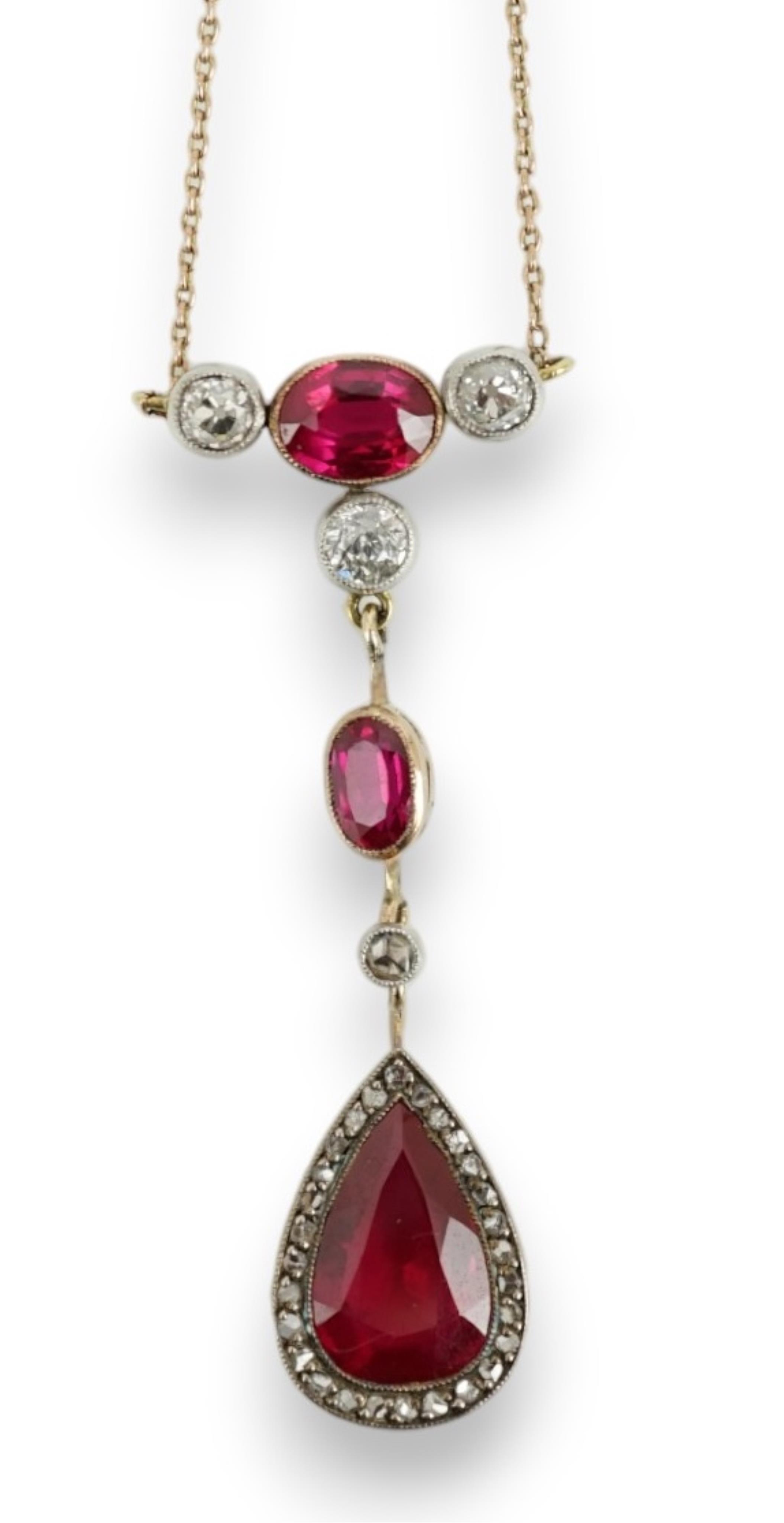 A 9ct, three stone synthetic ruby and four stone diamond set drop pendant necklace, pendant section 49mm, gross weight 5.2 gram.